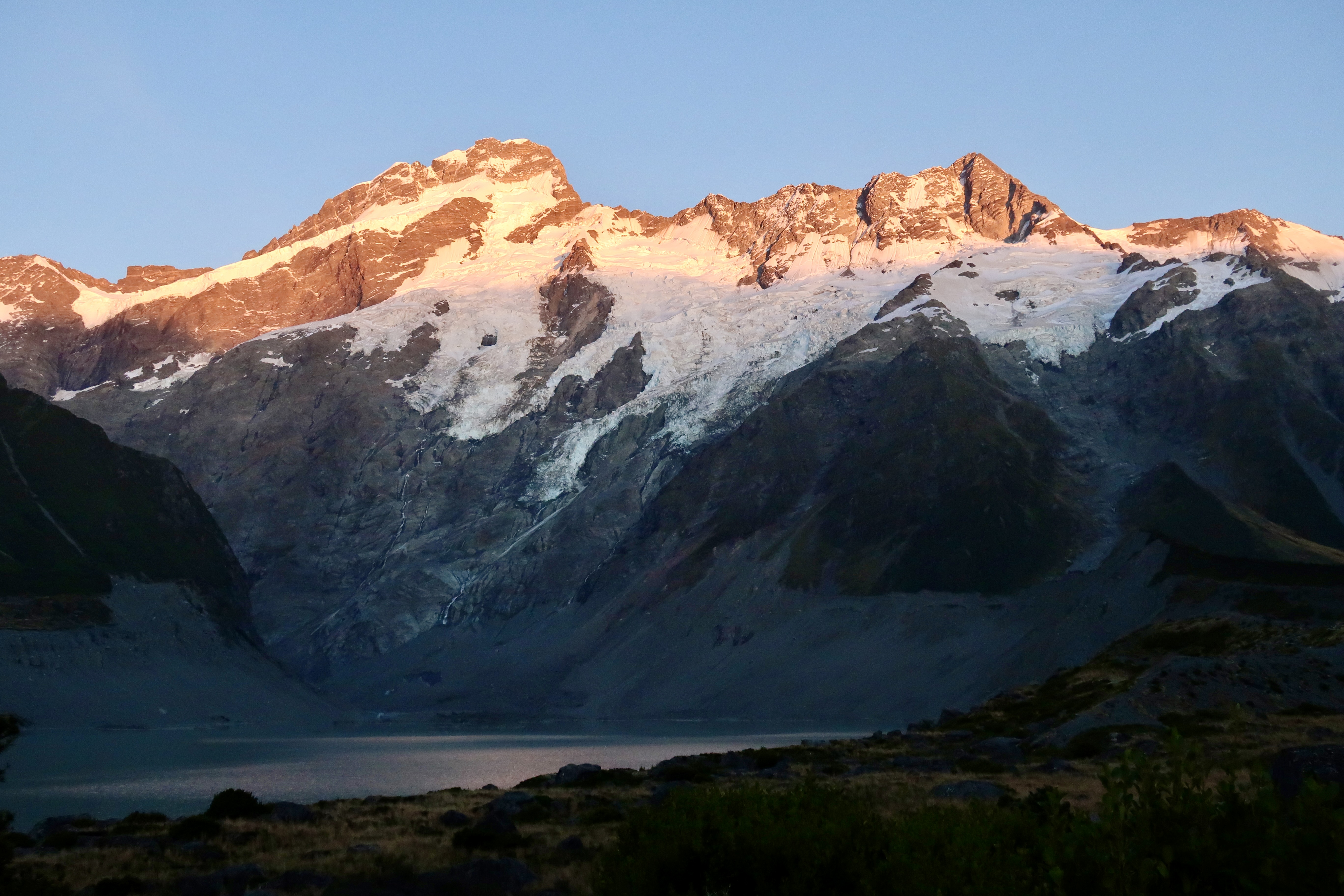 Sunrise light on snow-capped Patagonian peaks above a glacial lake